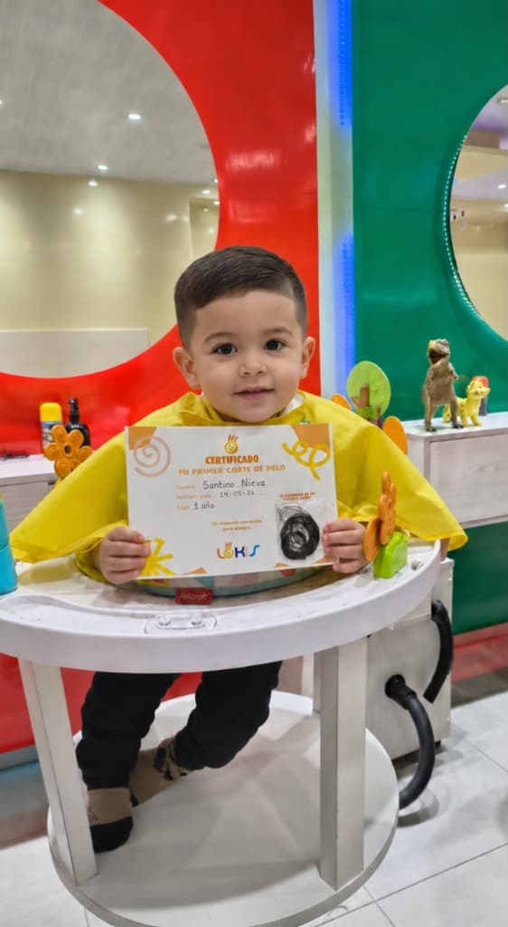 Bebé feliz con su certificado de primer corte